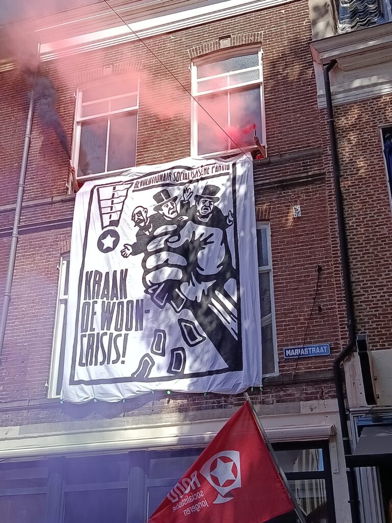 Spandoek na de kraak met het logo van de RPS en 'kraak de wooncrisis!' erop