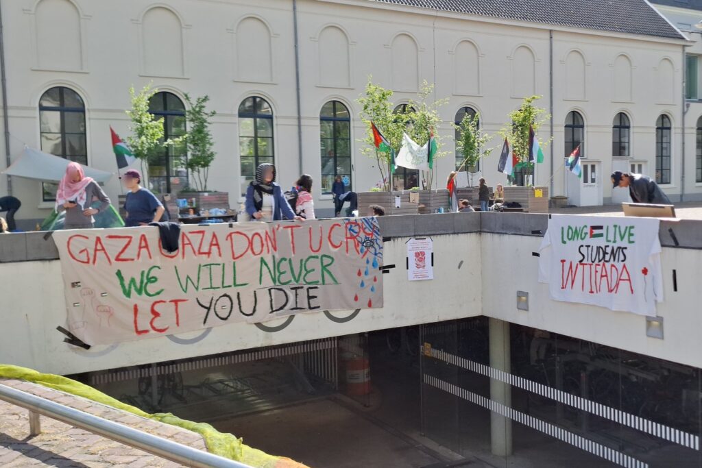 kameraden staan bij een spandoek op het kampement
