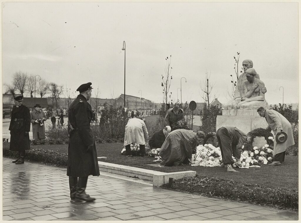 Deelnemers aan de Hannie Schaft Herdenking leggen een krans bij het oorlogsmonument aan de Rijksstraatweg bij de Jan Gijzenbrug, jaren 80.